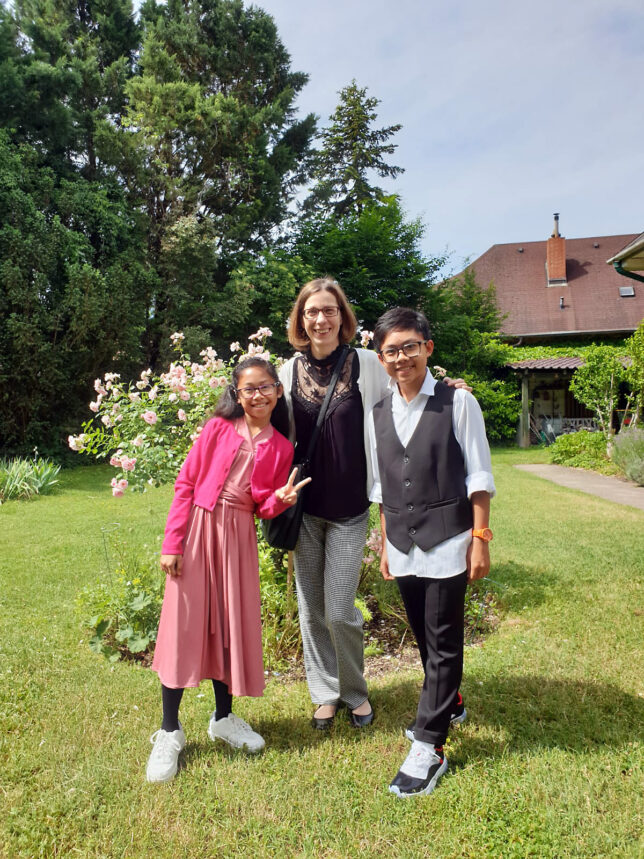 Ryan und Rose-Ann Bacay mit ihrer Klavierlehrerin im Garten des Musiksalons